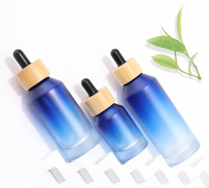 Flacon en verre bleu dégradé avec compte-gouttes en bambou pour emballage cosmétique