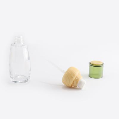 Bouteille en verre cosmétique transparente avec couvercle en bambou
