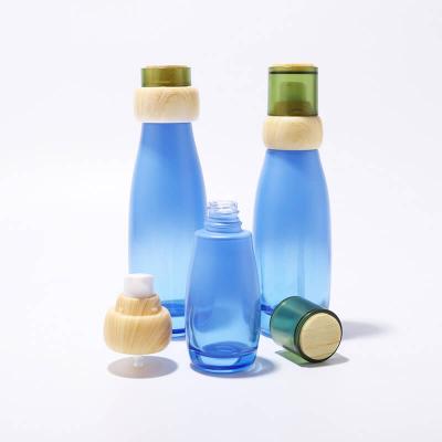 Ensemble de bouteilles en verre rondes en gros avec couvercle en bambou dans les soins de la peau pour les emballages cosmétiques